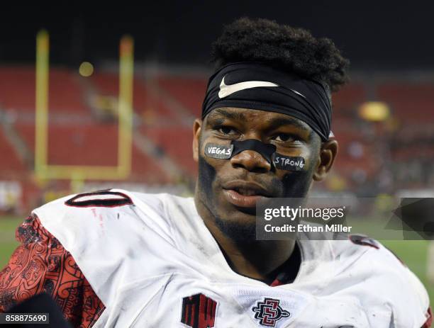 Running back Rashaad Penny of the San Diego State Aztecs wears eye black stickers with the words "Vegas Strong" on them as he is interviewed on the...