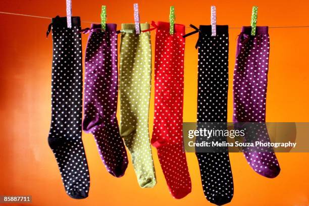 polka dots socks hanging on washing line - wäscheklammer stock-fotos und bilder