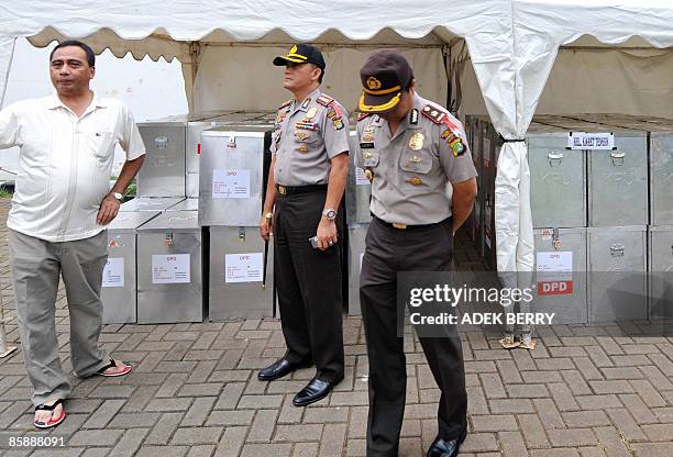 Indonesian police officers inspect sealed ballot boxes at a subdistrict office in Jakarta on April 10 before a national tabulation which will start...