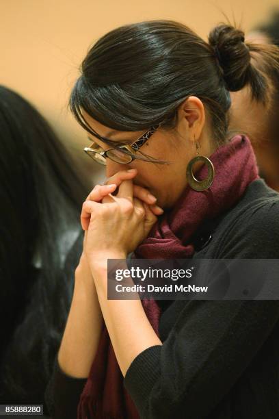 Woman prays during the celebration of the Mass of the Lord's Supper, where Cardinal Roger Mahony washed the feet of 12 people, following the example...