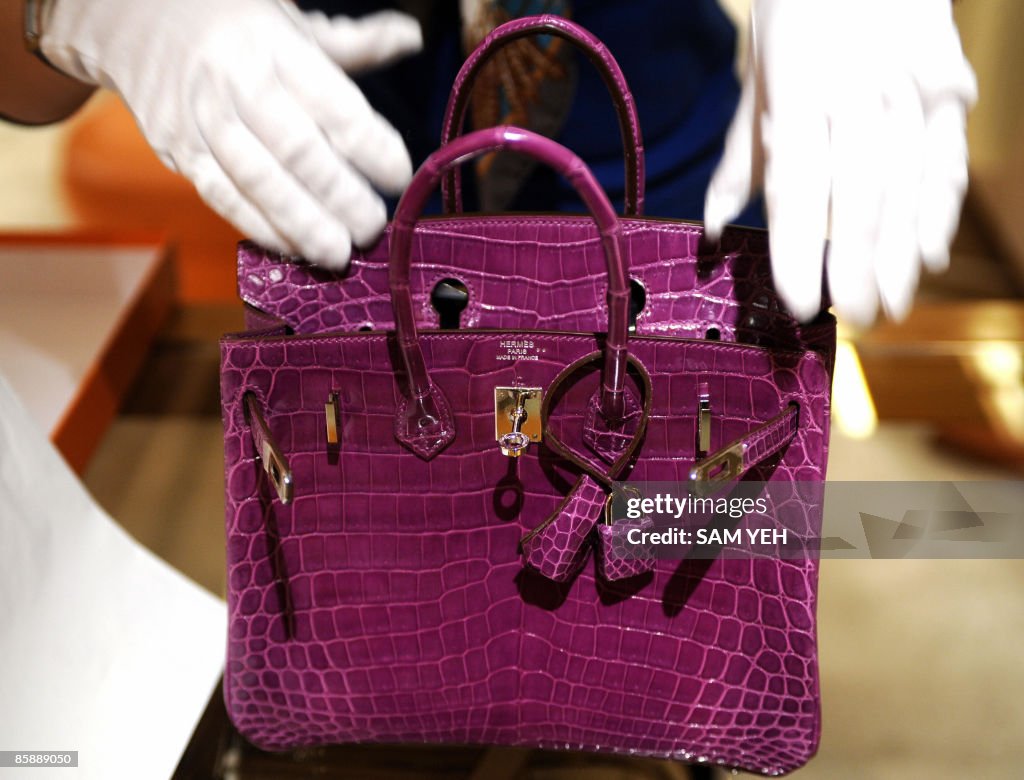 A woman inspects Hermes crocodile skin bag in Taipei on April 10
