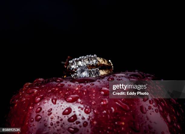 anillo en manzana roja y verde con gotas de agua y fondo negro - fondo negro stockfoto's en -beelden