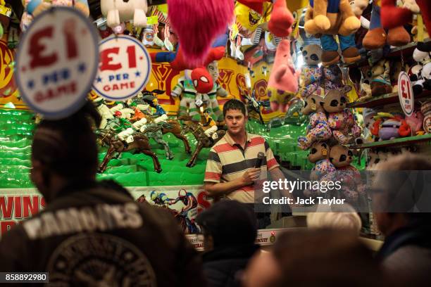 Man works at a fun fair game at the Nottingham Goose Fair in the Forest Recreation Ground on October 7, 2017 in Nottingham, England. The annual goose...