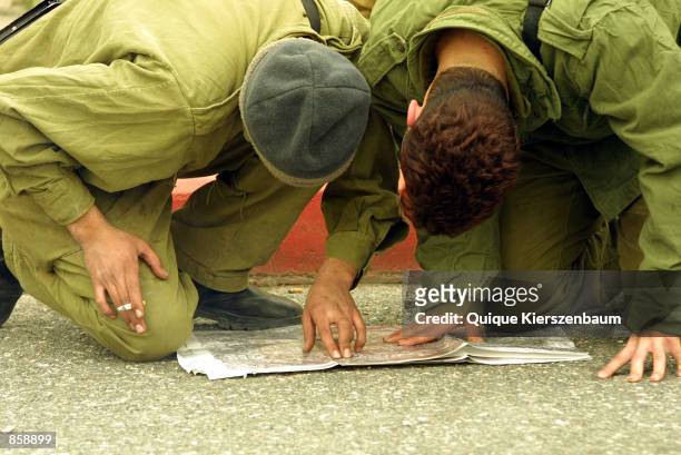 Israeli reservist soldiers look at a map March 31, 2002 at the northern entrance to the Palestinian town of Bethlehem. IFD recruited 20, 000...