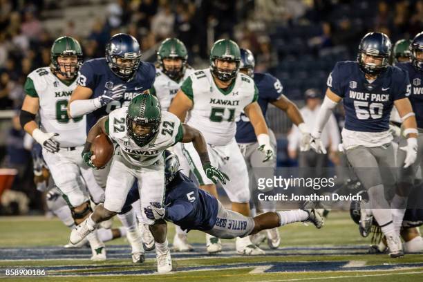 Running back Diocemy Saint Juste of the Hawaii Rainbow Warriors is tackled by defensive back Dameon Baber of the Nevada Wolf Pack at Mackay Stadium...