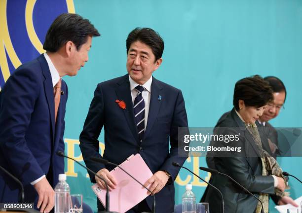 Shinzo Abe, Japan's prime minister and president of the Liberal Democratic Party , second left, speaks with Natsuo Yamaguchi, chief representative of...