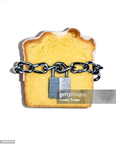 slice of pound cake with lock and chain - cake stockfoto's en -beelden