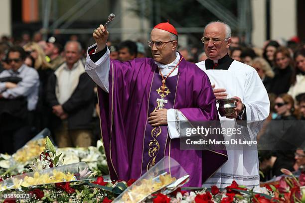 Cardinal Tarcisio Bertone Vatican Secretary of State blesses the coffins of the victims of the earthquake in Southern Italy during the funeral at the...