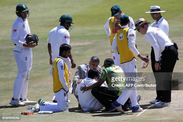 Bangladesh batsman Mushfiqur Rahim is attended by medics and team members after he was hit on the head by a ball delivered by South Africa bowler...