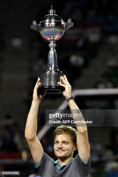 David Goffin of Belgium holds the trophy during the awarding ceremony after their men's singles final match against Adrian Mannarino of France during...