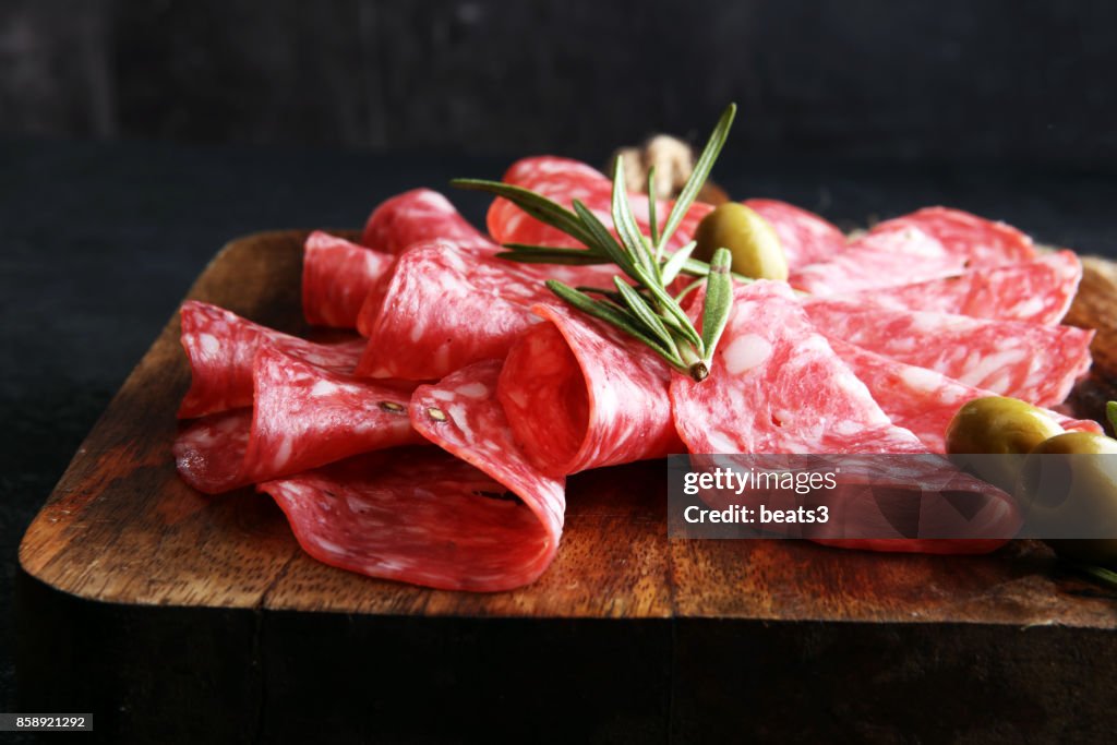 Thinly sliced salami on a wooden cuttingboard