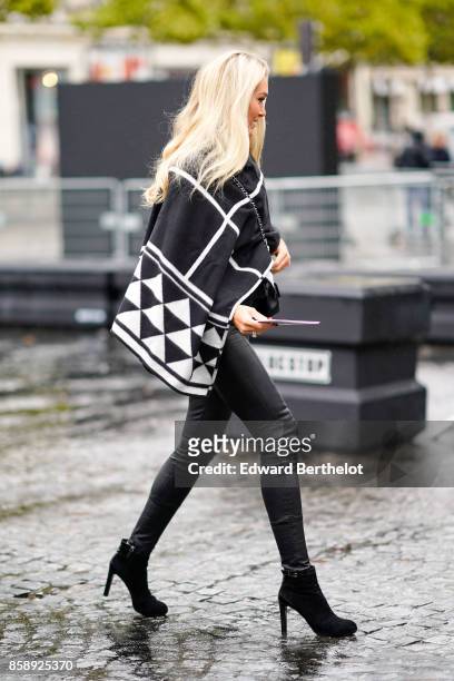 Guest wears a black and white print cape, and attends Le Defile L'Oreal Paris as part of Paris Fashion Week Womenswear Spring/Summer 2018 at Avenue...