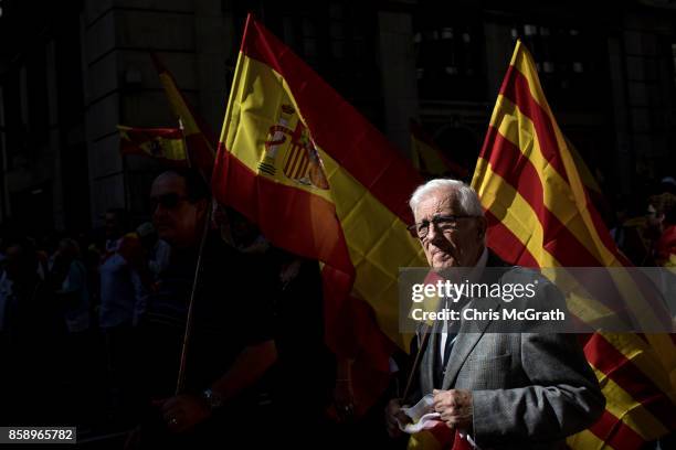 Man carries a Spanish national flag as he takes during a protest against Catalonia's indepedence on October 8, 2017 in Barcelona, Spain. Large...