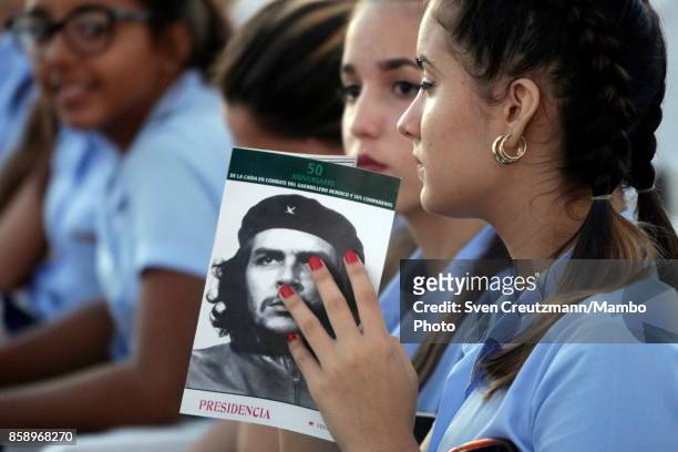 Cuban students hold images of Che Guevara prior to a political act at the Plaza de la Revolucion to celebrate the 50th anniversary of the death of...