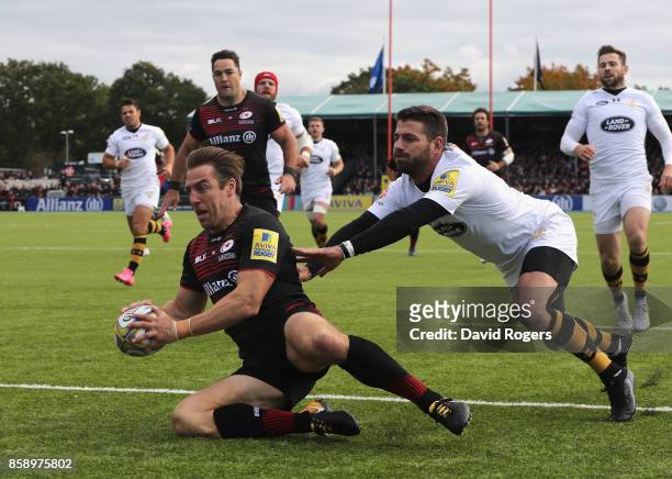 Chris Wyles of Saracens scores the first try as Willie le Roux attempts to tackle during the Aviva Premiership match between Saracens and Wasps at...