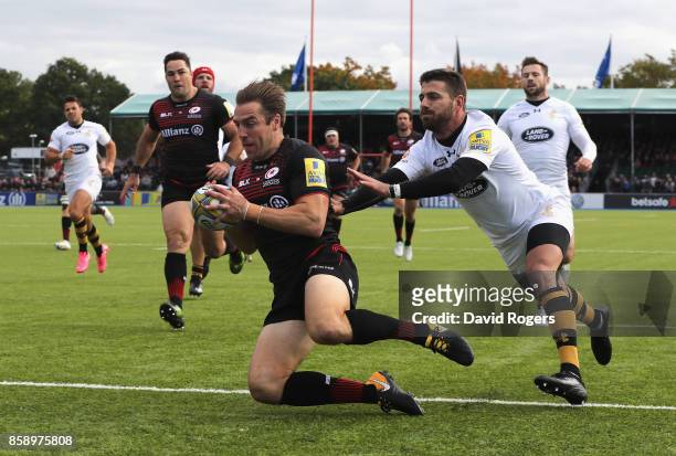 Chris Wyles of Saracens scores the first try as Willie le Roux attempts to tackle during the Aviva Premiership match between Saracens and Wasps at...