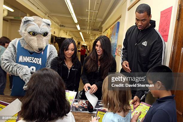 Jason Collins of the Minnesota Timberwolves along with team mascot Crunch and members of the Minnesota Timberwolves Dance Team hand out gifts during...