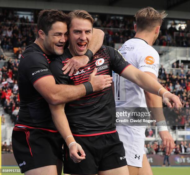 Chris Wyles of Saracens celebrates with team mate Brad Barritt after scoring the first try during the Aviva Premiership match between Saracens and...