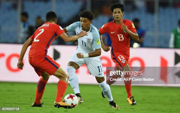 England's Jadon Sancho and Chile's Gaston Zuniga fight for the ball during the group stage football match between England and Chile in the FIFA U-17...