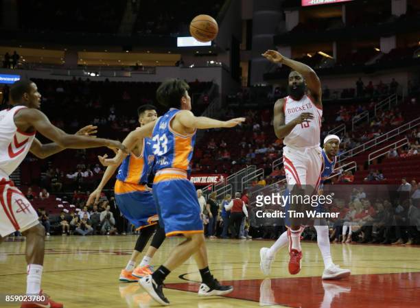 James Harden of Houston Rockets passes the ballin front of Luo Hanchen of Shanghai Sharks in the first half at Toyota Center on October 5, 2017 in...