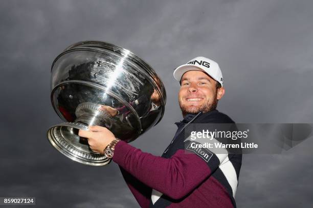 Tyrrell Hatton of England celebrates victory with the trophy following the final round of the 2017 Alfred Dunhill Championship at The Old Course on...