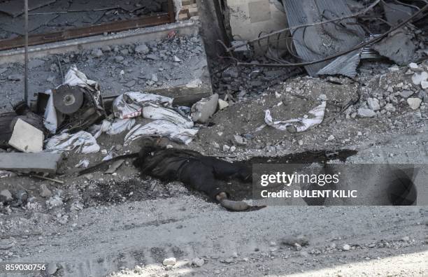 Graphic content / A body lies on a street on the western frontline in the Syrian city of Raqa on October 8, 2017. Syrian Democratic Forces , Syrian...