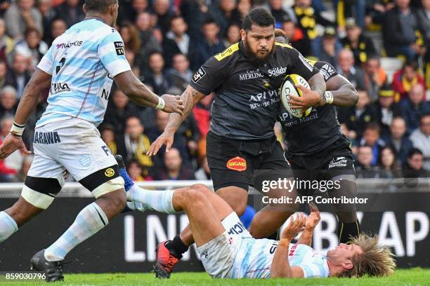 La Rochelle's French prop Vincent Pelo runs with the ball as Racing 92 hooker Dimitri Szarzewski falls during the French Top 14 rugby union match...