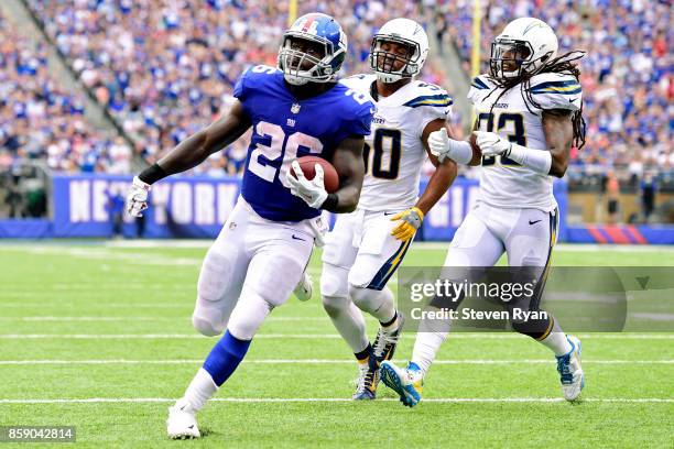 Orleans Darkwa of the New York Giants runs the ball past Charmeachealle Moore and Tre Boston of the Los Angeles Chargers for a first quarter...