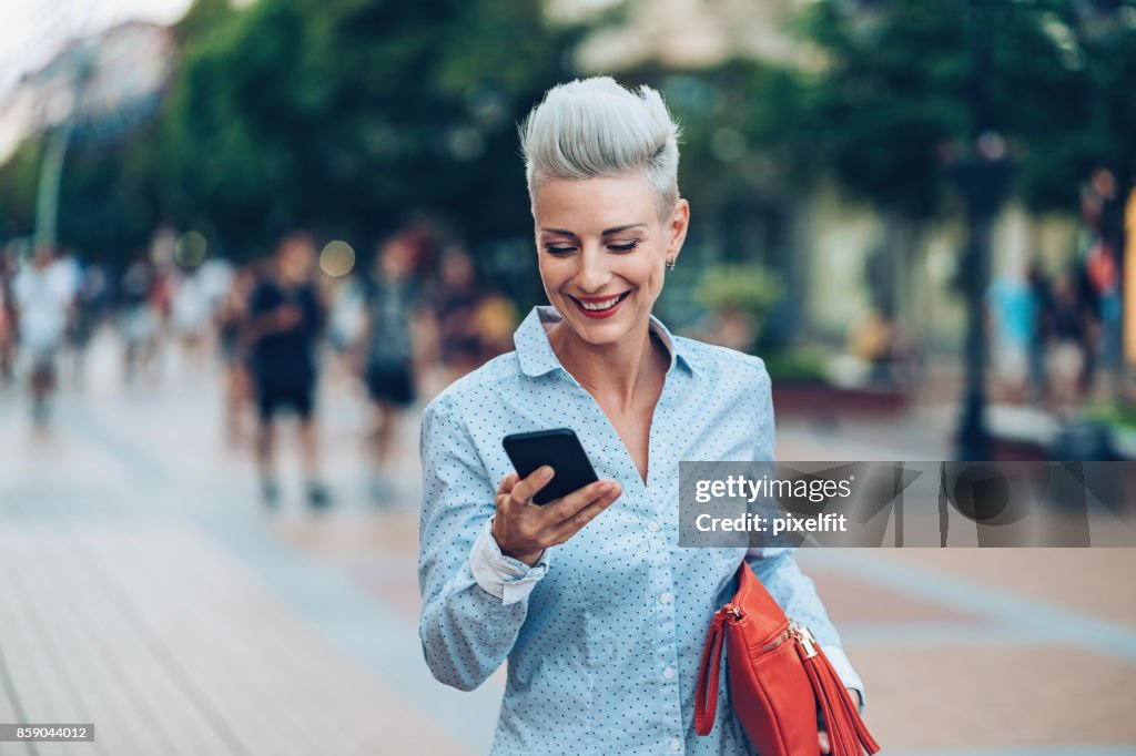 Happy Mid Aged Woman Texting On The Street High-Res Stock Photo - Getty ...