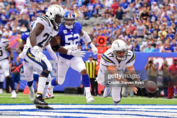Philip Rivers of the Los Angeles Chargers throws the ball out of the endzone for a safety after a muffed snap under pressure from Jonathan Casillas...