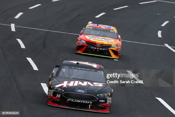 Kurt Busch, driver of the Monster Energy/Haas Automation Ford, leads Matt Kenseth, driver of the Tide Pods Toyota, during the Monster Energy NASCAR...