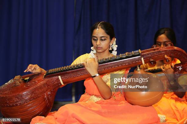 Tamil Hindu girls perform a devotional song on the veena during a Carnatic music program in Scarborough, Ontario, Canada.