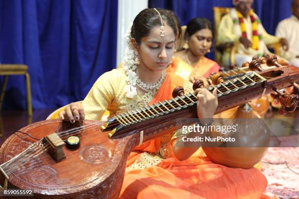 Tamil Hindu girls perform a devotional song on the veena during a Carnatic music program in Scarborough, Ontario, Canada.