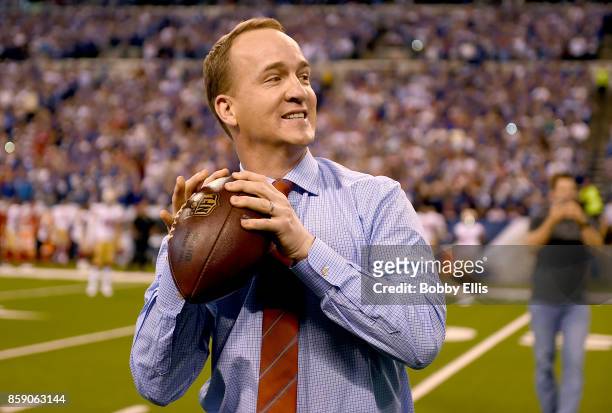 Peyton Manning steps back to throw a pass to former teammate Marvin Harrison during a presentation to retire Manning's number during the halftime of...