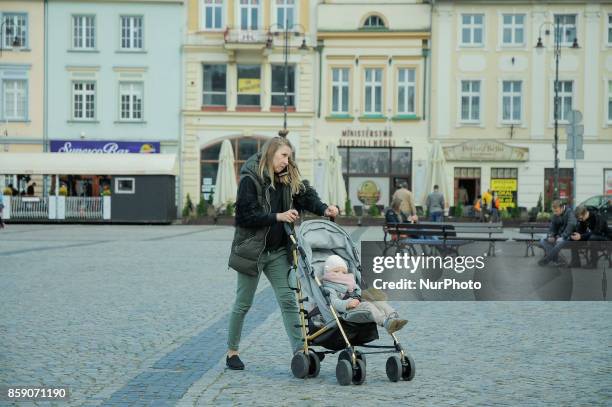 Young woman is seen walking with a child in a stroller on the Old Market Square on October 8, 2017 in Bydgoszcz, Poland.