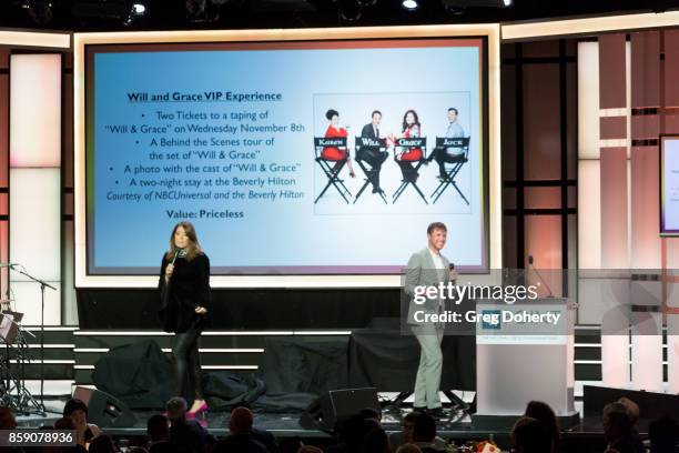 Host and Comedian Michelle Collins and Auctioneer Gabriel Butu on stage at the Point Honors Los Angeles at The Beverly Hilton Hotel on October 7,...