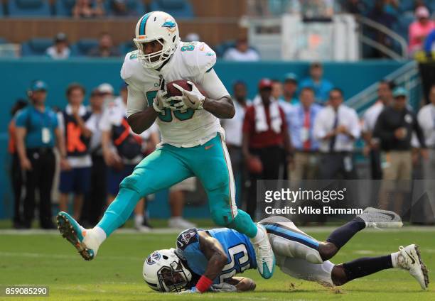 Julius Thomas of the Miami Dolphins tries to avoid the tackle of Adoree' Jackson of the Tennessee Titans in the fourth quarter on October 8, 2017 at...