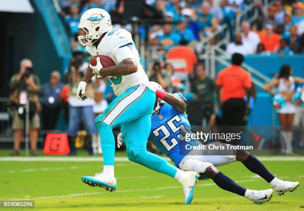 Julius Thomas of the Miami Dolphins tries to avoid the tackle of Adoree' Jackson of the Tennessee Titans in the fourth quarter on October 8, 2017 at...