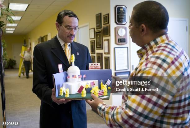 Vote staffer Eugene Kinlow, in checked shirt, shows off the "Give DC Peeps the Vote" diorama to D.C. Council Chairman Vincent C. Gray during a tour...