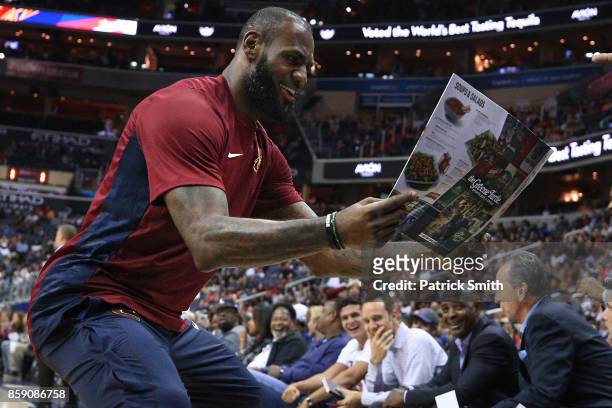 LeBron James of the Cleveland Cavaliers celebrates with teammates as he looks at a Greene Turtle restaurant menu after teammate Jeff Green · dunked...