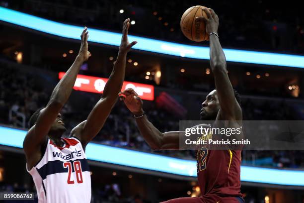 Jeff Green of the Cleveland Cavaliers dunks over Ian Mahinmi of the Washington Wizards in the first half during a preseason game at Capital One Arena...