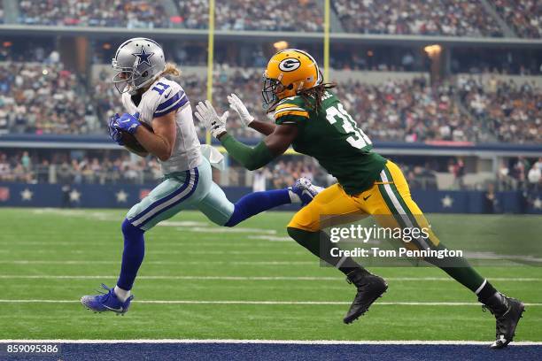Cole Beasley of the Dallas Cowboys pulls in a pass ahead of Davon House of the Green Bay Packers on the way to a touchdown in the first quarter of a...