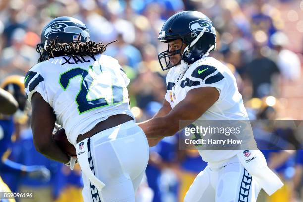 Russell Wilson of the Seattle Seahawks hands the ball of to Eddie Lacy of the Seattle Seahawks during the first quarter of the game against the Los...