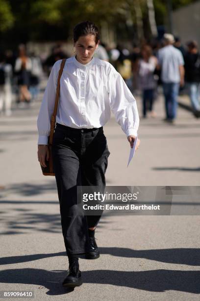 Guest wears a white shirt, black flare pants, black shoes, outside Nina Ricci, during Paris Fashion Week Womenswear Spring/Summer 2018, on September...