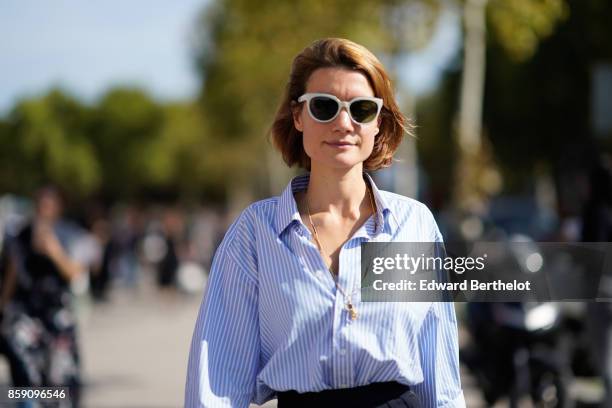 Guest wears sunglasses and a striped shirt, outside Nina Ricci, during Paris Fashion Week Womenswear Spring/Summer 2018, on September 29, 2017 in...