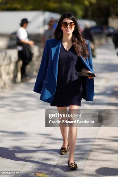 Guest wears a blue blazer jacket, a black dress, leopard print shoes, outside Nina Ricci, during Paris Fashion Week Womenswear Spring/Summer 2018, on...