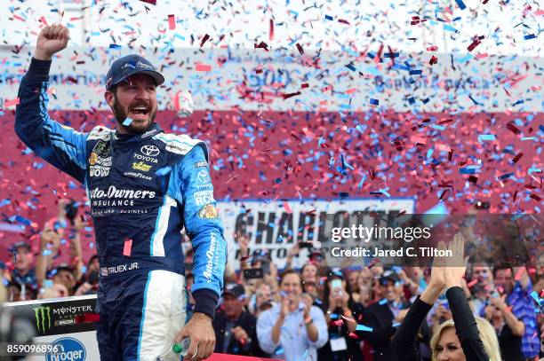 Martin Truex Jr, driver of the Auto-Owners Insurance Toyota, celebrates in Victory Lane after winning the Monster Energy NASCAR Cup Series Bank of...