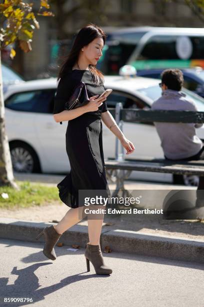 Guest wears a black dress, outside Nina Ricci, during Paris Fashion Week Womenswear Spring/Summer 2018, on September 29, 2017 in Paris, France.