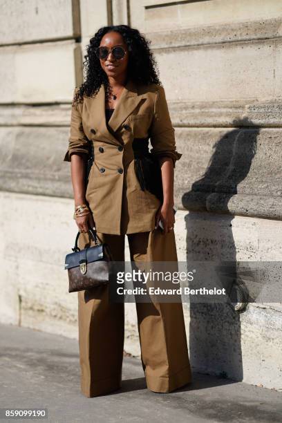 Guest wears sunglasses, a suit, a Vuitton bag, outside Nina Ricci, during Paris Fashion Week Womenswear Spring/Summer 2018, on September 29, 2017 in...