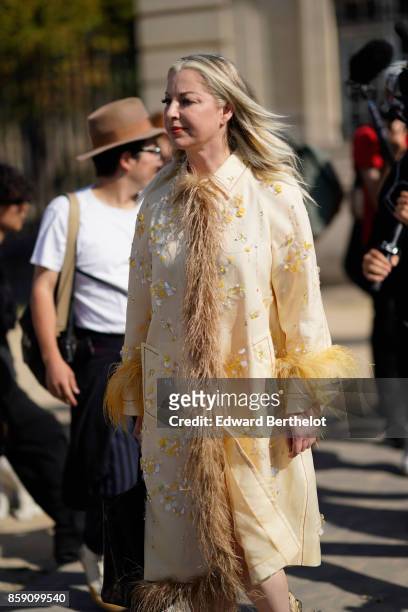 Guest wears a coat with fur lining, outside Nina Ricci, during Paris Fashion Week Womenswear Spring/Summer 2018, on September 29, 2017 in Paris,...